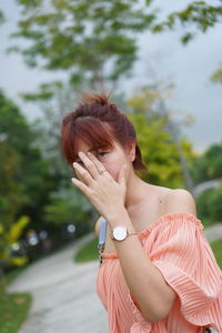 Portrait of young woman holding umbrella standing outdoors