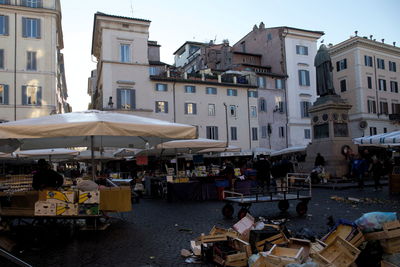 Group of people in market against buildings in city