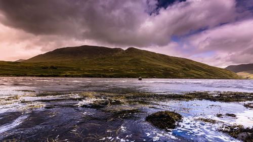 Scenic view of lake against cloudy sky