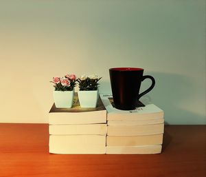 Coffee cup on table against wall