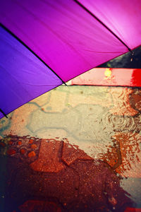 Close-up of wet pink umbrella against sky during monsoon