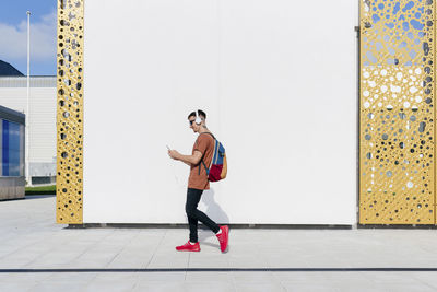 Portrait of young man standing against wall