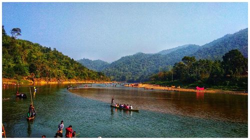 Group of people on lake against mountains