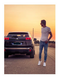 Man standing on street against sky during sunset