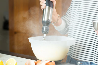 Woman kneading the dough while cooking apple pie in the modern kitchen