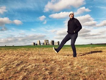 Full length portrait of man standing on field against sky