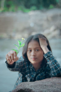 Portrait of boy holding plant