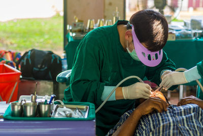 Male dentist operating patient in hospital