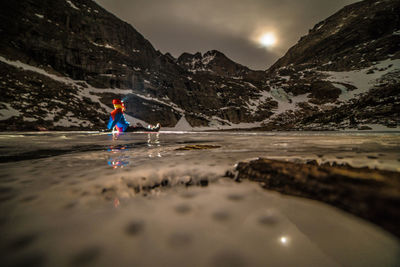 Rear view of man on mountain against sky