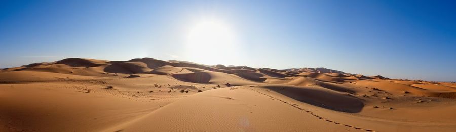 Scenic view of desert against clear blue sky