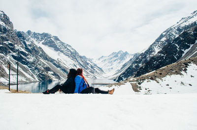 Rear view of person on snowcapped mountains against sky