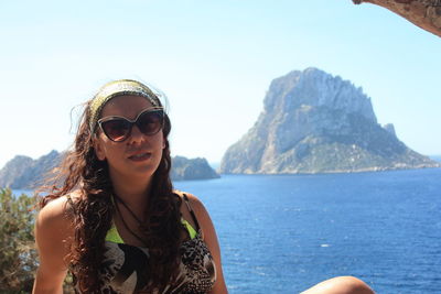 Portrait of young woman wearing sunglasses on mountain