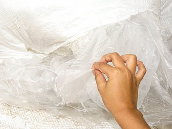 Cropped hand of woman holding plastic bag