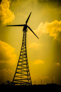 Low angle view of silhouette cranes against sky during sunset