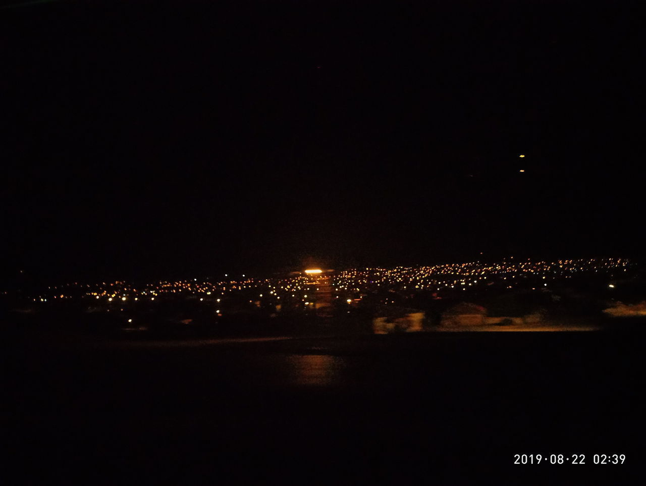 HIGH ANGLE VIEW OF ILLUMINATED CITY BUILDINGS AT NIGHT