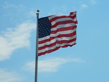 Low angle view of flag against blue sky