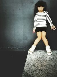 Full length of a young woman standing on tiled floor