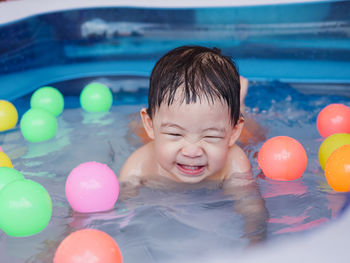 Portrait of boy with toy in swimming pool