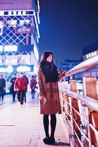 Woman standing in city at night