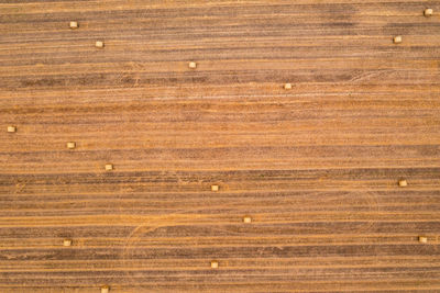 Full frame shot of some round bales of straw in a brown field seen from a drone point of view