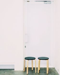 Empty stools by white door in room