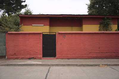 Exterior of house with red and orange wall in a village, talca, chile, south america
