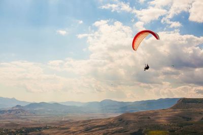 Hot air balloon flying over landscape against sky