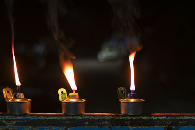 Close-up of lit candles in temple