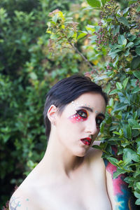 Portrait of young woman against plants