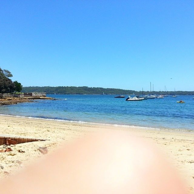 clear sky, sea, water, beach, copy space, blue, sand, transportation, tranquil scene, tranquility, shore, nautical vessel, scenics, beauty in nature, boat, nature, horizon over water, mode of transport, coastline, idyllic