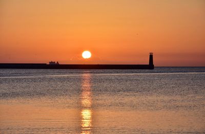 Scenic view of sea against orange sky