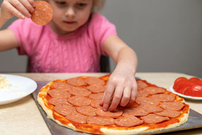 Girl preparing pizza at home