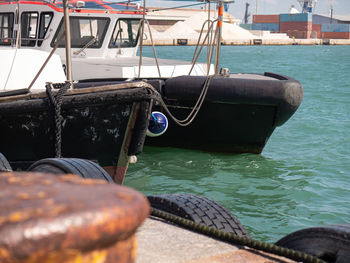 Detail of the bow of two small moored boats used as tugs in port.