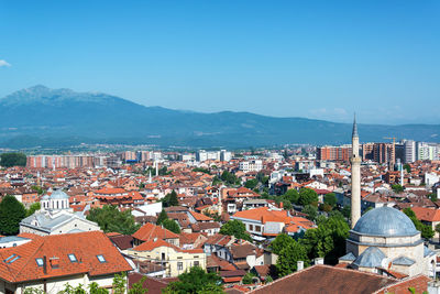 Aerial view of cityscape against clear blue sky