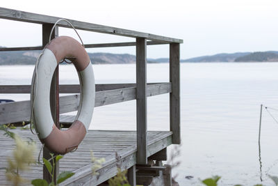 Close-up of hand holding boat in sea against sky