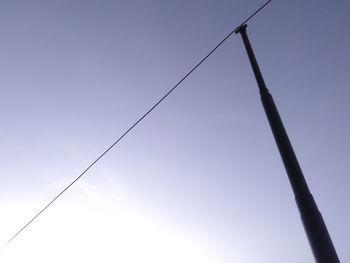 Low angle view of power lines against clear blue sky