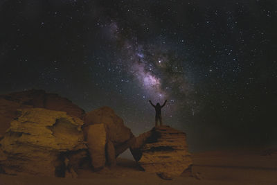 Low angle view of woman standing against star field