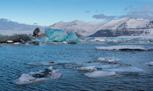 Icebergs in sea against sky during winter