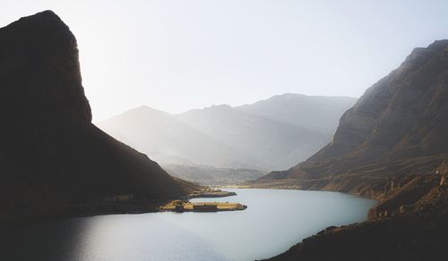 Scenic view of lake and mountains against clear sky