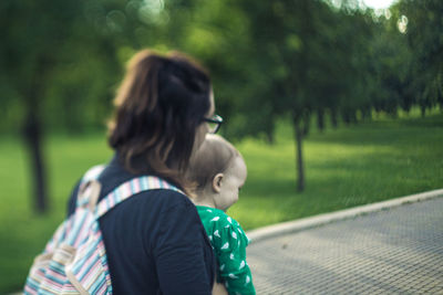 Rear view of mother and daughter in park