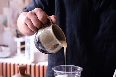 Midsection of man pouring drink in glass