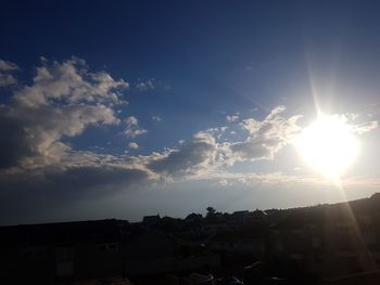 Sunlight streaming through silhouette buildings