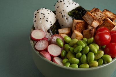 Vegan bowl with onigiri, tofu and vegetables