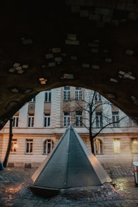 Building by street in city against sky