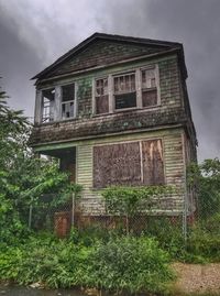 Low angle view of abandoned house against sky