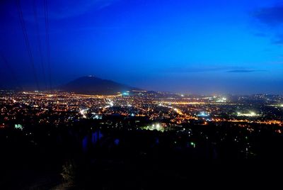 Illuminated cityscape against sky at night