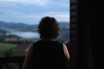 Rear view of woman standing in balcony