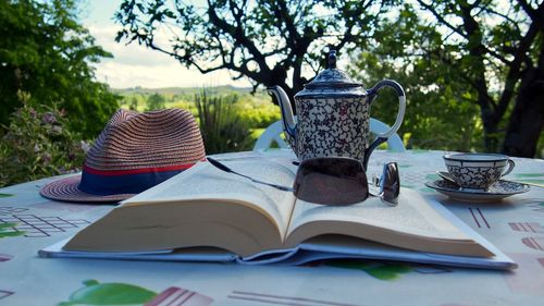 Open book on table against trees