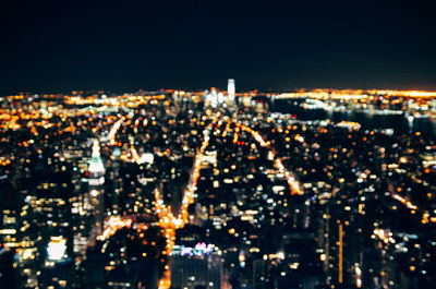 Illuminated cityscape against sky at night