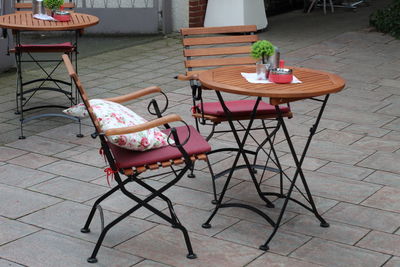 High angle view of empty chairs and tables at sidewalk cafe